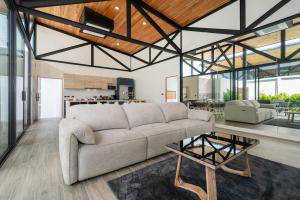 a living room with a couch and a table at Sunset Garden 16 - Eco Design Villa with Private Pool near Nai Harn Beach in Rawai Beach