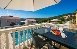 a table with a plate of food on a balcony at Cozy Apartment In Rabac With Wifi in Rabac