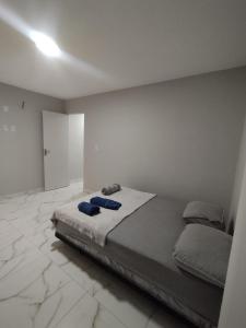 a bedroom with a bed with blue pillows on it at Apart Hotel São Pedro Inn Caxias sup in Santa Cruz da Serra