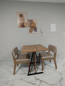 a wooden table and two chairs in a room at Apart Hotel São Pedro Inn Caxias sup in Santa Cruz da Serra