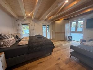 - une chambre avec un lit, du parquet et des fenêtres dans l'établissement Haus Am Faltenbach - Ferienhäuser Alpenglück, à Oberstdorf 7 autres photos