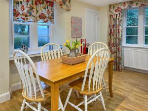 Un comedor con mesa y sillas de madera. en Baldowrie Lodge, en Ardler