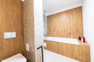 La salle de bains est pourvue de toilettes et de placards en bois. dans l'établissement Panoramic Penthouse Views - Cozy 2BR Retreat, à Vatra Mînăstirii Cotroceni 38 autres photos