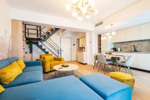 un salon avec un canapé bleu et une table dans l'établissement Panoramic Penthouse Views - Cozy 2BR Retreat, à Vatra Mînăstirii Cotroceni