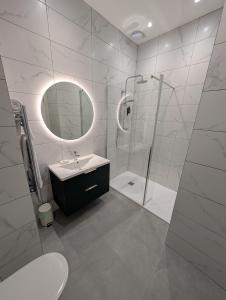 a white bathroom with a sink and a shower at Church Suites Enniskillen in Enniskillen +29 photos