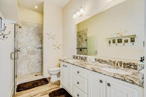 een badkamer met een wastafel, een toilet en een douche bij Stunning Gulf Views Hot Tub Group Ready in Bolivar Peninsula +39 foto's