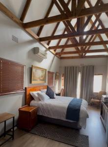 ein Schlafzimmer mit großem Bett und Holzdecken in der Unterkunft Madeley House Unit 1 near Oliver Tambo Airport in Boksburg
