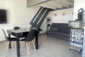 a living room with a table and a couch at Le Grisé in Aucamville