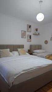 ティラナにあるMeraki Room Tirana Centerの大きな白いベッドとランプのある寝室 +13枚の写真