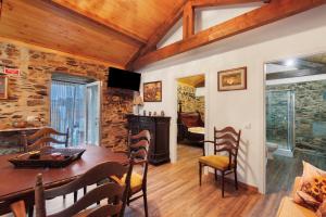 a dining room with a wooden table and chairs at Casas da Chica com Piscina, Arouca in Espiunca