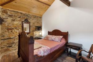 a bedroom with a bed and a stone wall at Casas da Chica com Piscina, Arouca in Espiunca +65 photos