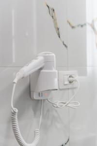 Ein weißes Telefon ist an eine Wand angeschlossen. in der Unterkunft Hotel Riti in Shirokë