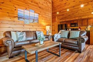 Sala de estar con 2 sofás de cuero y mesa de centro en Pinot Paradise, en Pigeon Forge