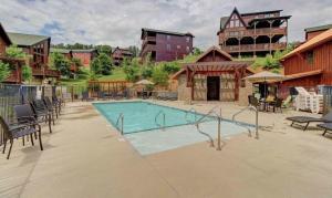Una piscina con sillas y un edificio. en Pinot Paradise, en Pigeon Forge