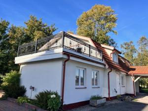 a house with a balcony on top of it at La Casa in Sölvesborg