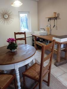 Una cocina con dos mesas y sillas y una mesa con flores. en Maisonnette cosy 2 chambres, en Freyming-Merlebach