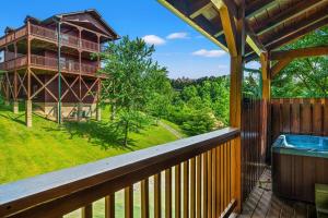 una terraza con bañera de hidromasaje y una casa en Pinot Paradise, en Pigeon Forge