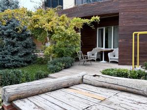 a wooden deck with a table and chairs on a house at Garda in Tashkent