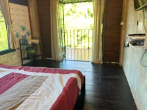 a bedroom with a bed and a large window at วิวดี ป่าเหมี้ยง โฮมสเตย์ in Ban Pa Miang