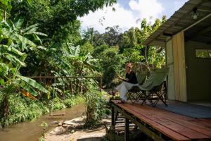 a woman sitting in a chair on a porch at วิวดี ป่าเหมี้ยง โฮมสเตย์ in Ban Pa Miang