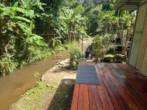 Ban Pa Miangにあるวิวดี ป่าเหมี้ยง โฮมสเตย์の川沿いの木製デッキに座っている人