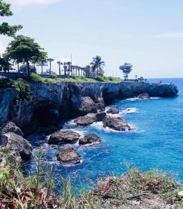 a rocky shoreline with rocks in the water at Moderno apartamento de estilo europeo en Santo Domingo Este in Ensanche Savica de Mendoza +10 photos