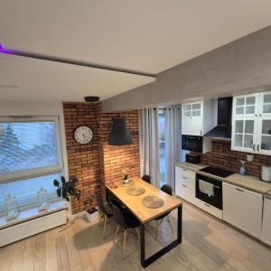 cocina con mesa y reloj en una pared de ladrillo en APATRAMET Królowej Jadwigi 12A, en Giżycko