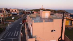 an aerial view of a building with a street and the ocean at Loft 102 Farol de Santa Marta in Laguna