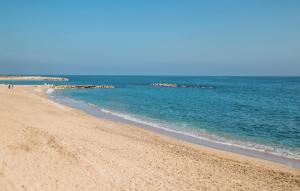 a beach with people walking on the sand and the water at 2 Bedroom Lovely Apartment In Vinaroz in Vinaròs