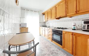 a kitchen with wooden cabinets and a table and a stove at 2 Bedroom Lovely Apartment In Vinaroz in Vinaròs