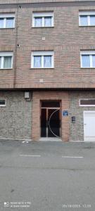 a brick building with a large doorway with a white door at Fogar Bardanca in Melide