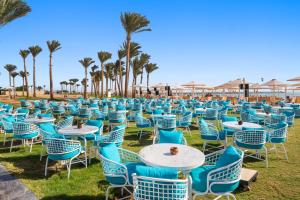 a group of chairs and tables and palm trees at Pickalbatros Laguna Vista Aqua Park - 24 HRS All Inclusive in Sharm El Sheikh +239 photos