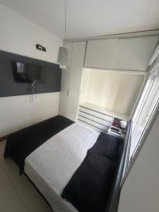 um pequeno quarto com uma cama e uma janela em Melhor apartamento de capão! 100m da praia em Capão da Canoa