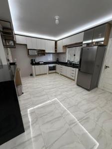 a large kitchen with white tile floors and stainless steel appliances at Casa de 4 Quartos - 2 suites in Ananindeua