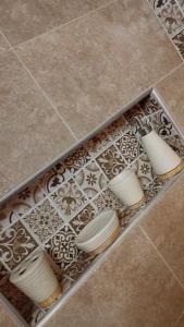 a box filled with white plates on a tile floor at Appartement meublé in Meknès