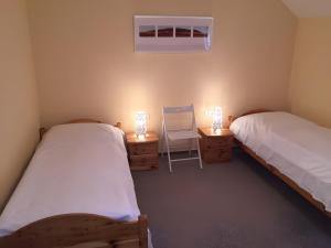 two beds in a room with a chair and two lamps at Weingut Ilmbacher Hof in Iphofen +28 photos