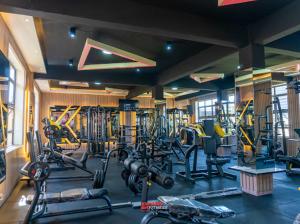 - une salle de sport avec plusieurs tapis de course et machines dans l'établissement Express living and wellness, à Jinja