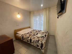 Petropavlovskaya BorshchagovkaにあるHouse&House 84のベッドと窓のある小さな寝室