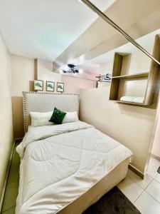 a small bedroom with a bed with white sheets at Oak South Gardens-South B in Nairobi