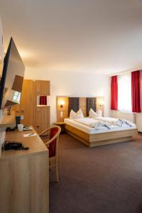 a hotel room with two beds and a desk at Hotel Rössle Berneck in Altensteig