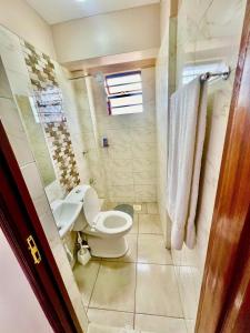 a bathroom with a toilet and a shower at Oak South Gardens-South B in Nairobi
