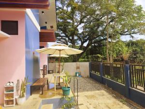 a patio with a table and an umbrella at Amwani Azure in Puerto Princesa City