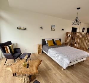 a bedroom with a bed and a chair at Le Calais Wilson 7 - Studio Balneo 2p in Calais