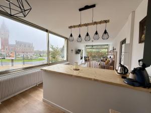 a kitchen with a counter and a large window at Le Calais Wilson 7 - Studio Balneo 2p in Calais
