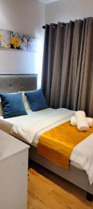 a bedroom with two beds with blue pillows at Convenient Davao Getaway in Davao City +31 photos