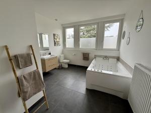 a bathroom with a tub and a toilet and a sink at Le Calais Wilson 7 - Studio Balneo 2p in Calais