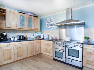 a kitchen with wooden cabinets and a stove top oven at Tean in Polruan