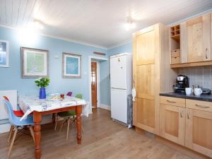 a kitchen with a table and chairs and a refrigerator at Tean in Polruan +17 photos