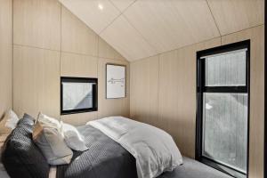 a bedroom with a large bed and a window at Kowhai Luxury Villa Queenstown in Queenstown Airport