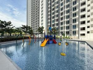 una piscina con parque infantil frente a un edificio en Self Check in Mirai Kajang 3BR, en Kajang